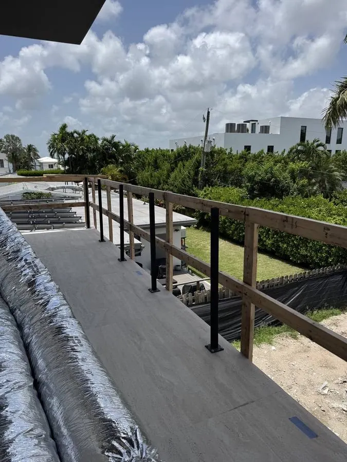 Glass railing installation in progress on a rooftop terrace
